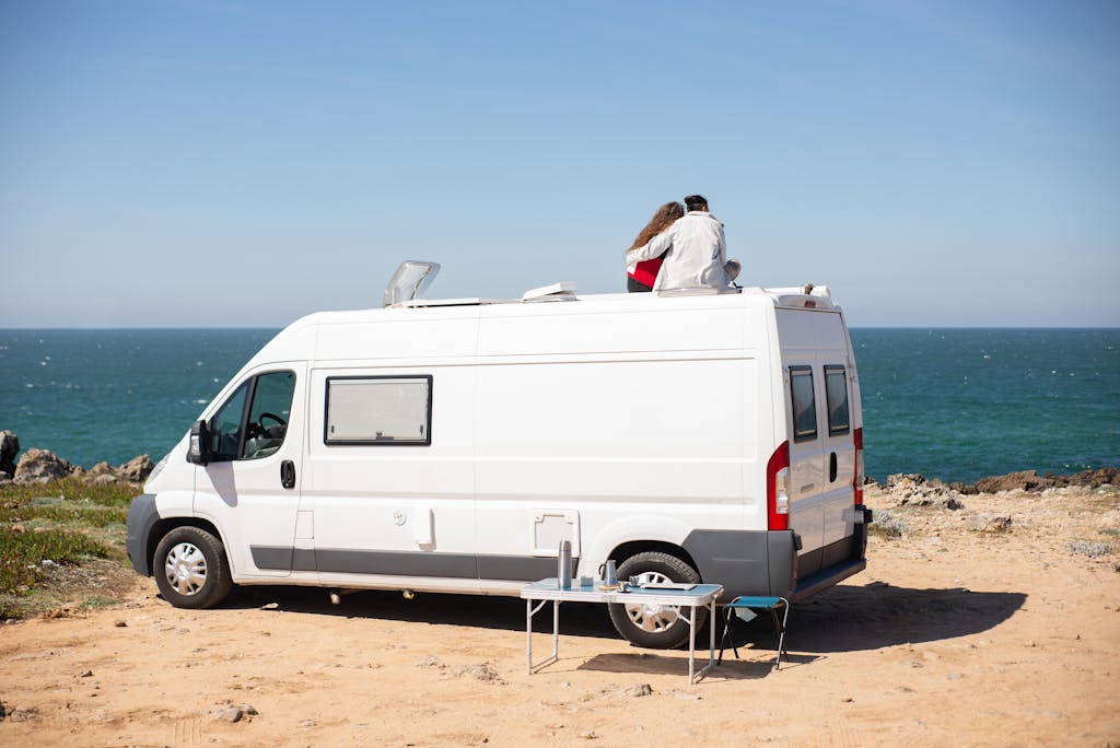 Back View of a Couple Sitting on Top of an RV